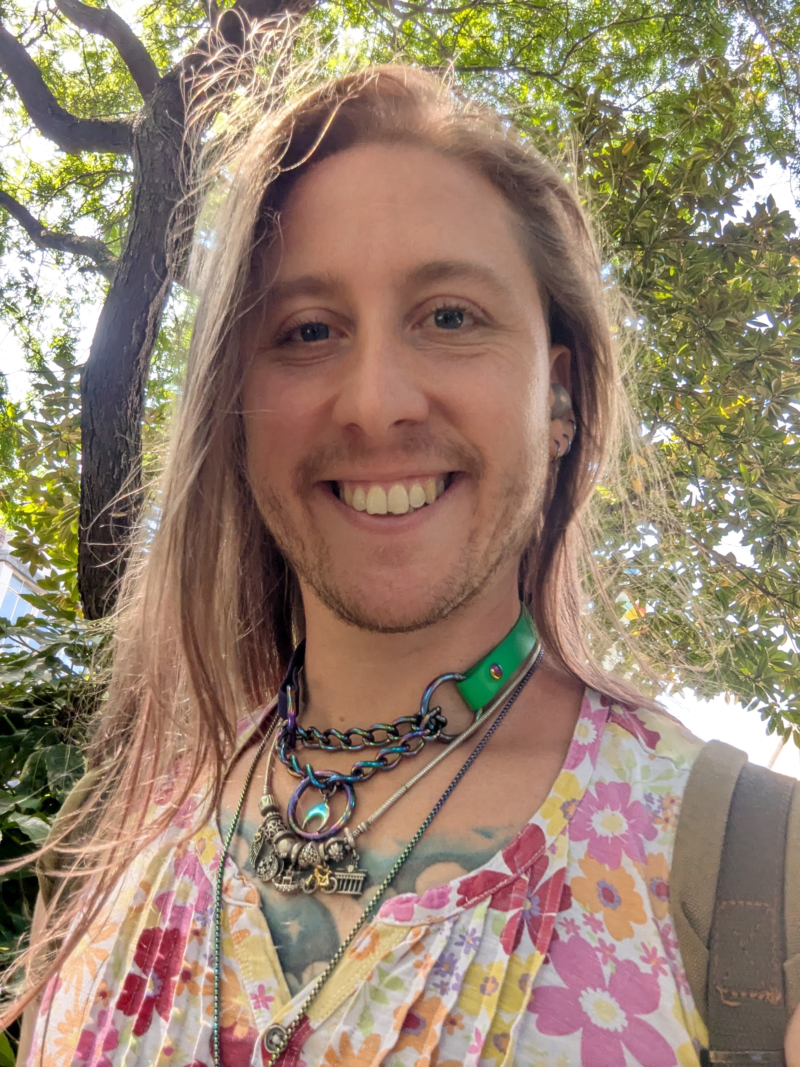 A picture of Io looking a mix of masc and femme having just had her hair cut